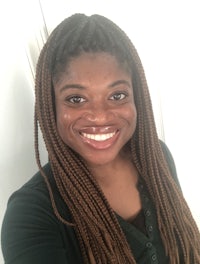 a woman with braided hair smiling for the camera